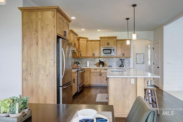 2581 N Tricia Way, Meridian, ID 83646 - kitchen with stainless steel appliances, a sink, arched walkways, tasteful backsplash, and light countertops