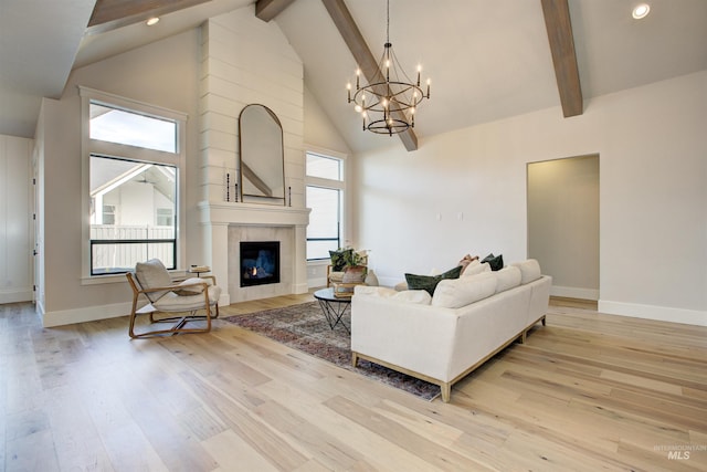 living area with high vaulted ceiling, a chandelier, beam ceiling, wood finished floors, and a tiled fireplace