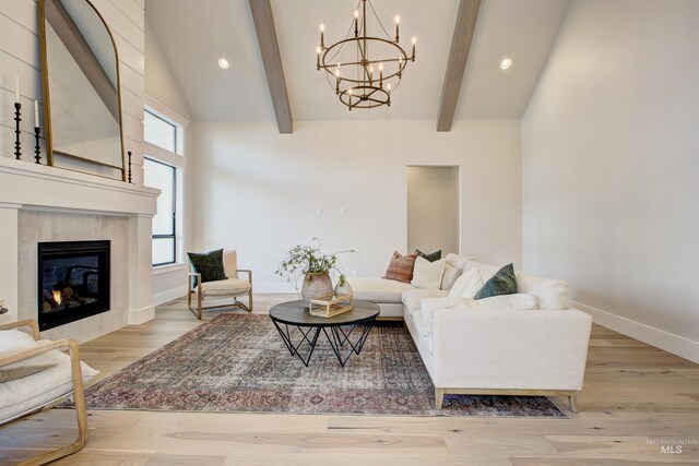 living area with beamed ceiling, a chandelier, light wood-style floors, recessed lighting, and a fireplace