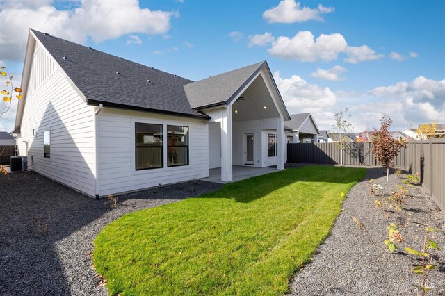 rear view of property featuring a patio area, central AC unit, and roof with shingles