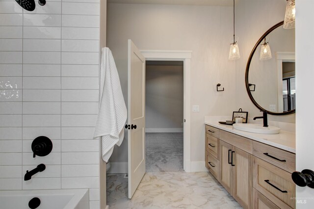 full bath featuring marble look tile flooring, vanity, baseboards, and shower / washtub combination