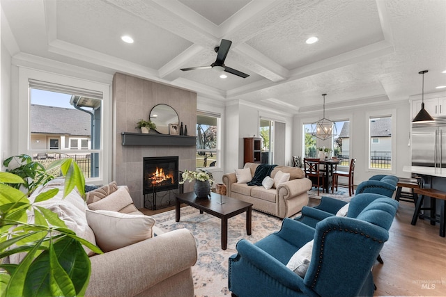 2255 N Sugar Loop Ave, Star, ID 83669 - living room featuring healthy amount of natural light, a tiled fireplace, coffered ceiling, wood finished floors, and recessed lighting