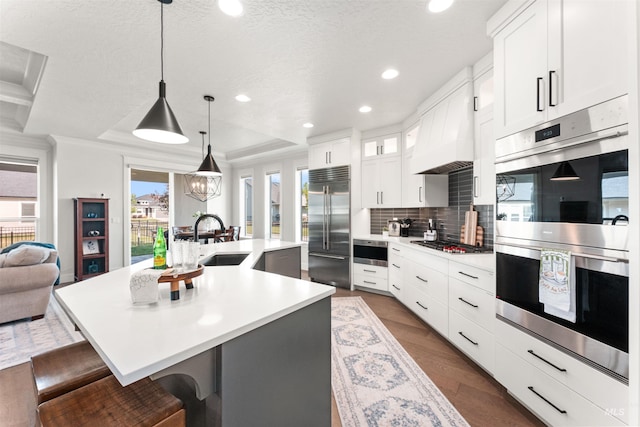 2255 N Sugar Loop Ave, Star, ID 83669 - kitchen featuring appliances with stainless steel finishes, a kitchen island with sink, light countertops, tasteful backsplash, and a breakfast bar area