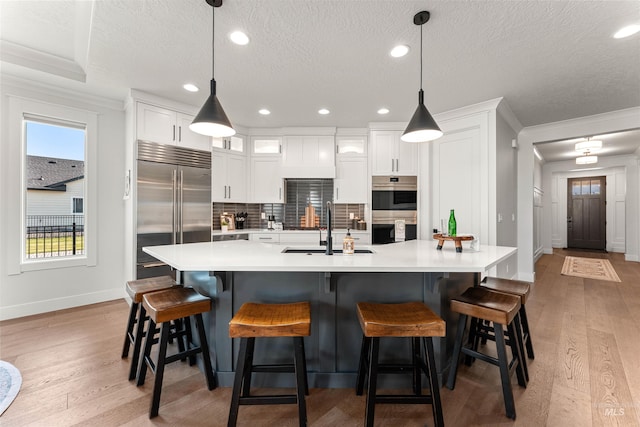 2255 N Sugar Loop Ave, Star, ID 83669 - kitchen featuring appliances with stainless steel finishes, light wood-type flooring, light countertops, white cabinets, and recessed lighting