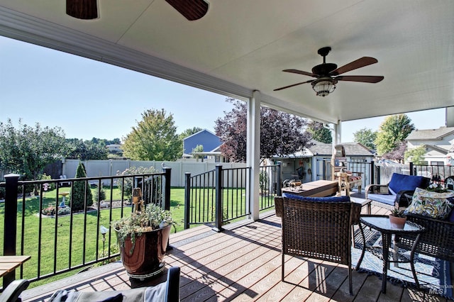 wooden terrace with a yard, an outdoor hangout area, a ceiling fan, a residential view, and a fenced backyard