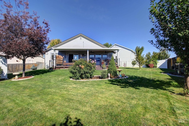 view of front of property featuring a front yard, fence, and a wooden deck