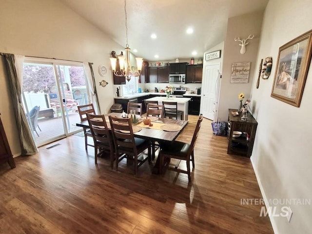 dining area featuring a chandelier, high vaulted ceiling, dark wood finished floors, and visible vents