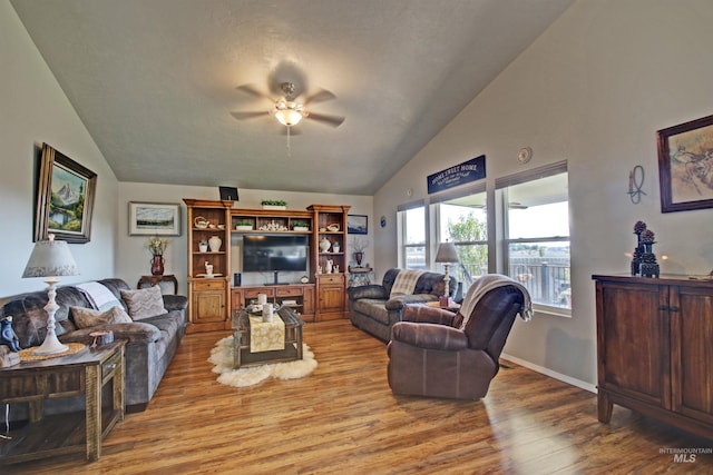 living room featuring vaulted ceiling, wood finished floors, a ceiling fan, and baseboards