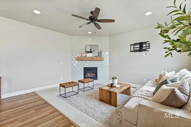 2065 Sombrero Ave, Middleton, ID 83644 - living area featuring wood finished floors, a ceiling fan, a tiled fireplace, and recessed lighting