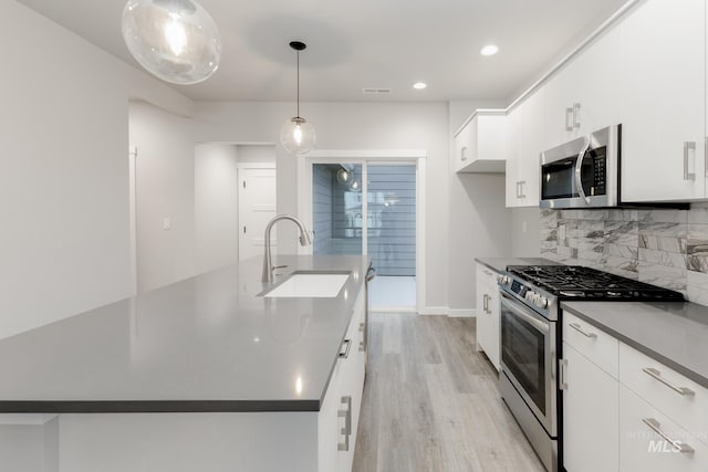 6760 S Cheyenne Ave, Boise, ID 83709 - kitchen with a sink, stainless steel appliances, light wood-style floors, white cabinetry, and backsplash