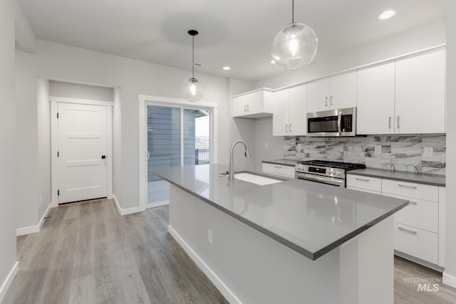 6760 S Cheyenne Ave, Boise, ID 83709 - kitchen with a sink, stainless steel appliances, light wood-type flooring, tasteful backsplash, and baseboards