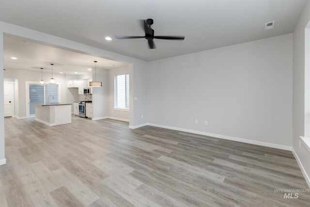 6760 S Cheyenne Ave, Boise, ID 83709 - unfurnished living room featuring recessed lighting, a sink, baseboards, light wood-type flooring, and a ceiling fan