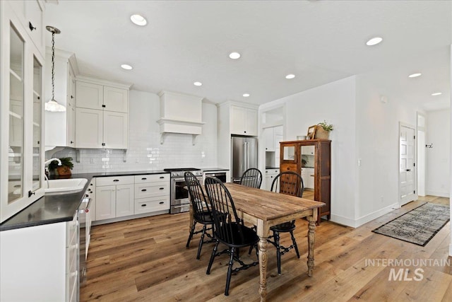 dining space featuring recessed lighting, light wood-style flooring, and baseboards