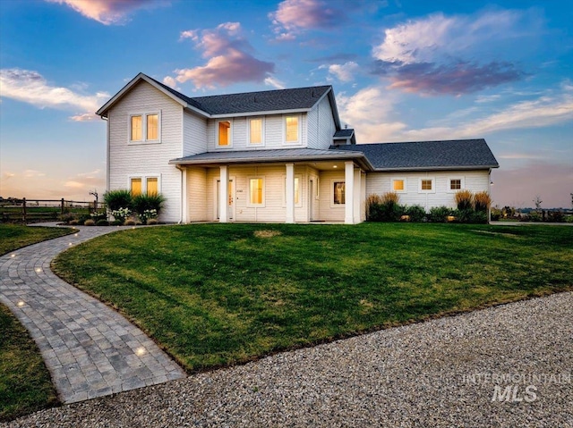 view of front of home with a yard and fence