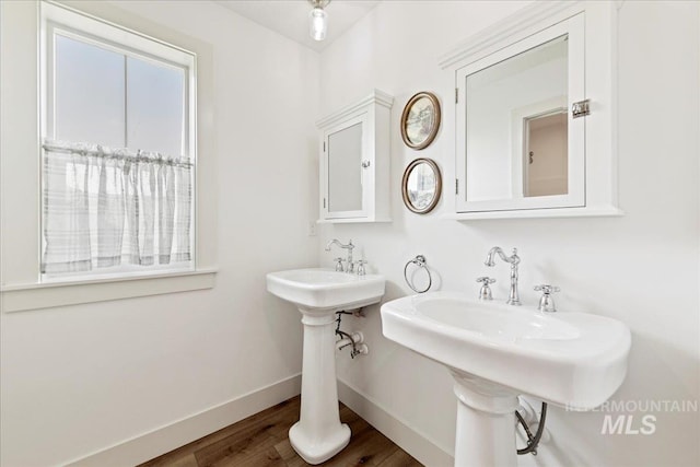 bathroom with wood finished floors, baseboards, and a sink