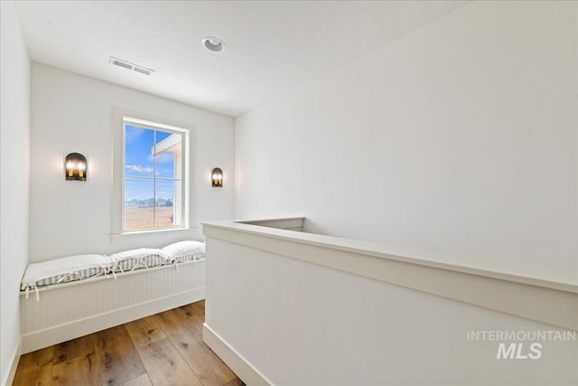 hall featuring visible vents and light wood-style floors