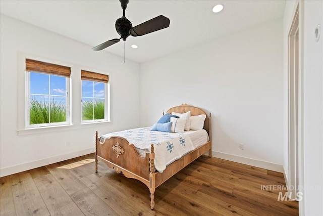 bedroom with recessed lighting, baseboards, and wood-type flooring