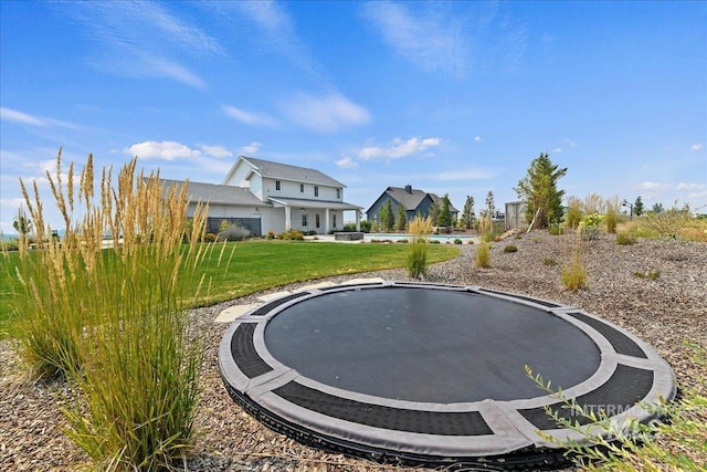 view of home's community with a yard and a trampoline