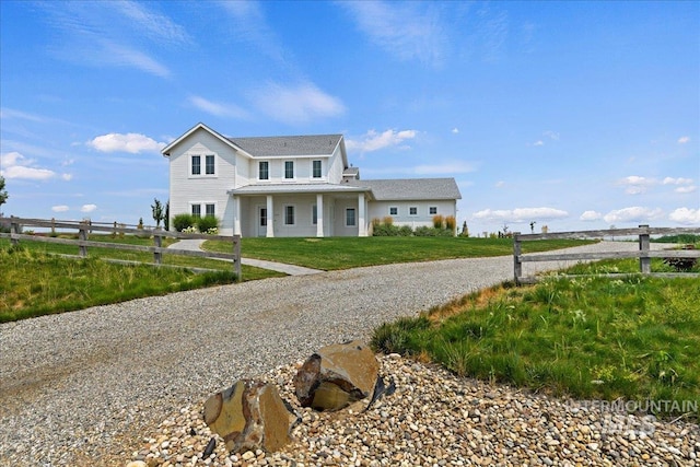 view of front of property featuring driveway, a front yard, and fence