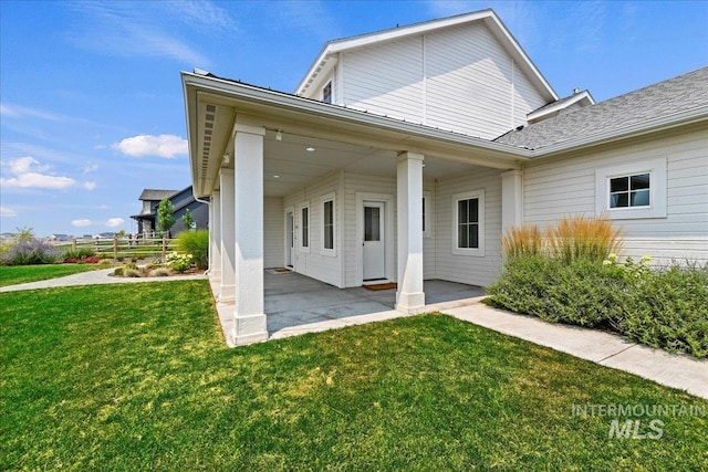 back of property featuring a patio and a yard