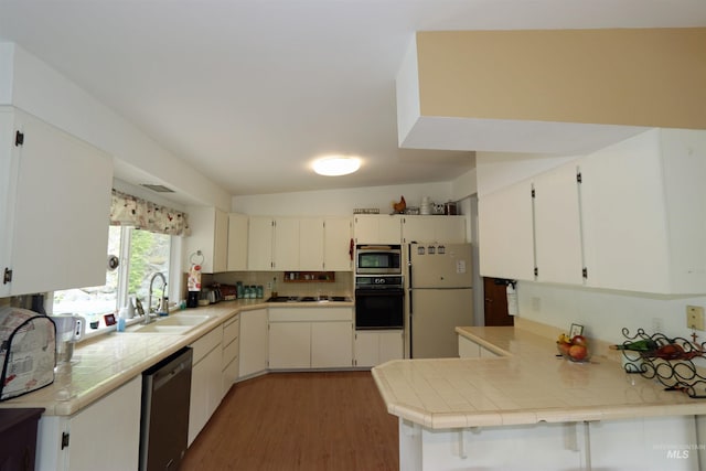 34 Locust Dr, Orofino, ID 83544 - kitchen featuring appliances with stainless steel finishes, a sink, light wood-style flooring, backsplash, and a peninsula