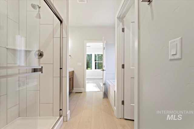 bathroom featuring hardwood / wood-style flooring, vanity, and independent shower and bath