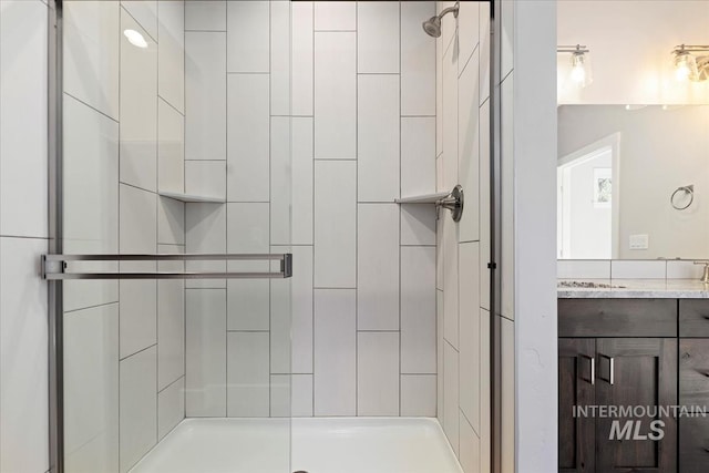 bathroom featuring vanity and a shower with shower door