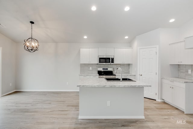 2089 N Thunderbolt St, Mountain Home, ID 83647 - kitchen featuring stainless steel appliances, backsplash, white cabinetry, a center island with sink, and pendant lighting