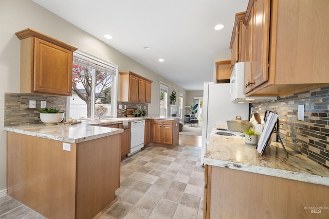 380 S Golden Eagle Ln, Eagle, ID 83616 - kitchen with white appliances, a peninsula, tasteful backsplash, recessed lighting, and light stone counters