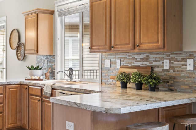 380 S Golden Eagle Ln, Eagle, ID 83616 - kitchen with light countertops, a peninsula, tasteful backsplash, and a breakfast bar