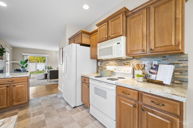 380 S Golden Eagle Ln, Eagle, ID 83616 - kitchen featuring white appliances, brown cabinetry, tasteful backsplash, light stone counters, and recessed lighting