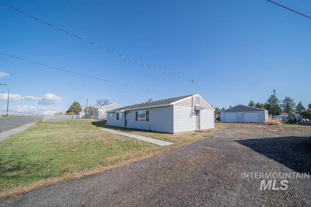 view of home's exterior with a garage, an outbuilding, and a lawn