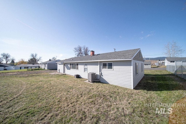 rear view of house featuring a yard and central AC unit