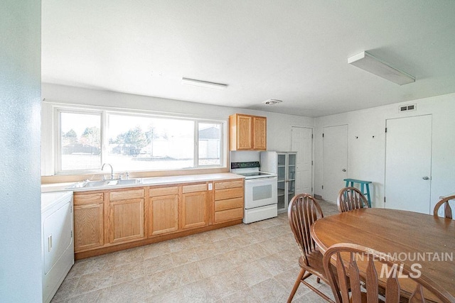 kitchen with sink, electric range, and washer / dryer