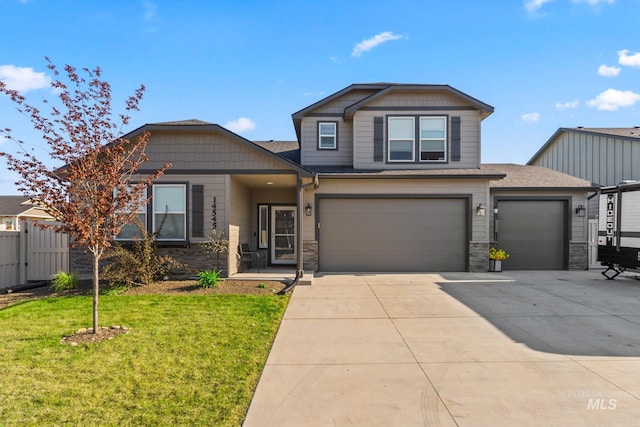 view of front of property with driveway, stone siding, an attached garage, and a garage