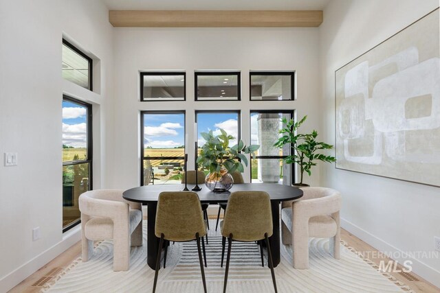 dining area with hardwood / wood-style flooring and beam ceiling