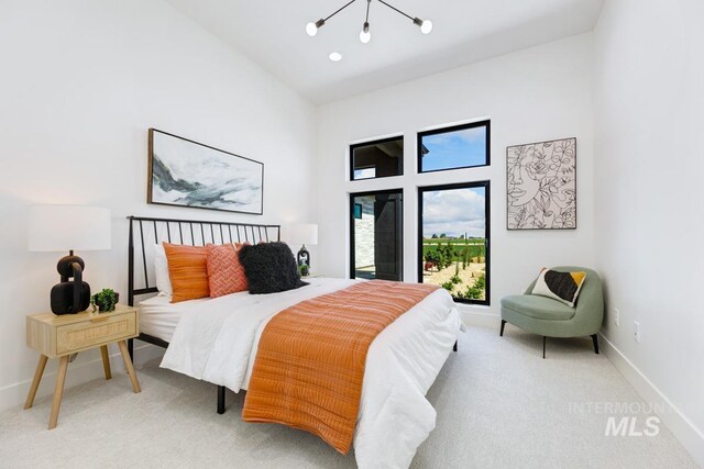 bedroom featuring carpet flooring, high vaulted ceiling, and an inviting chandelier