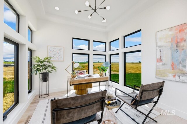 sunroom / solarium featuring a notable chandelier