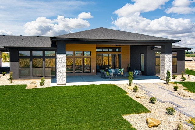 rear view of property featuring a patio area, an outdoor living space, and a yard