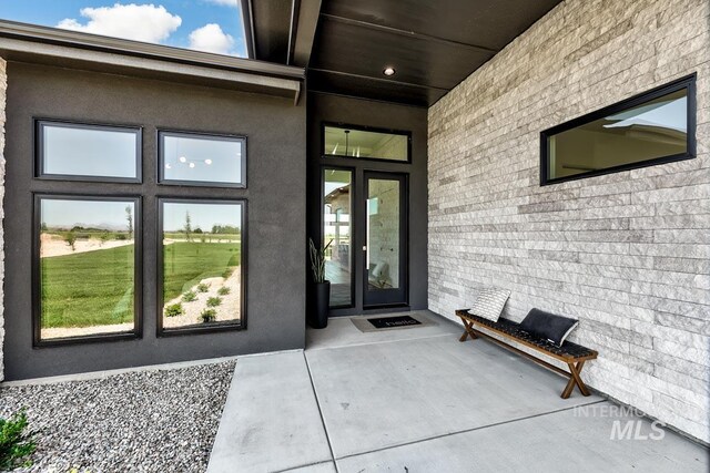 view of exterior entry with french doors and a patio area