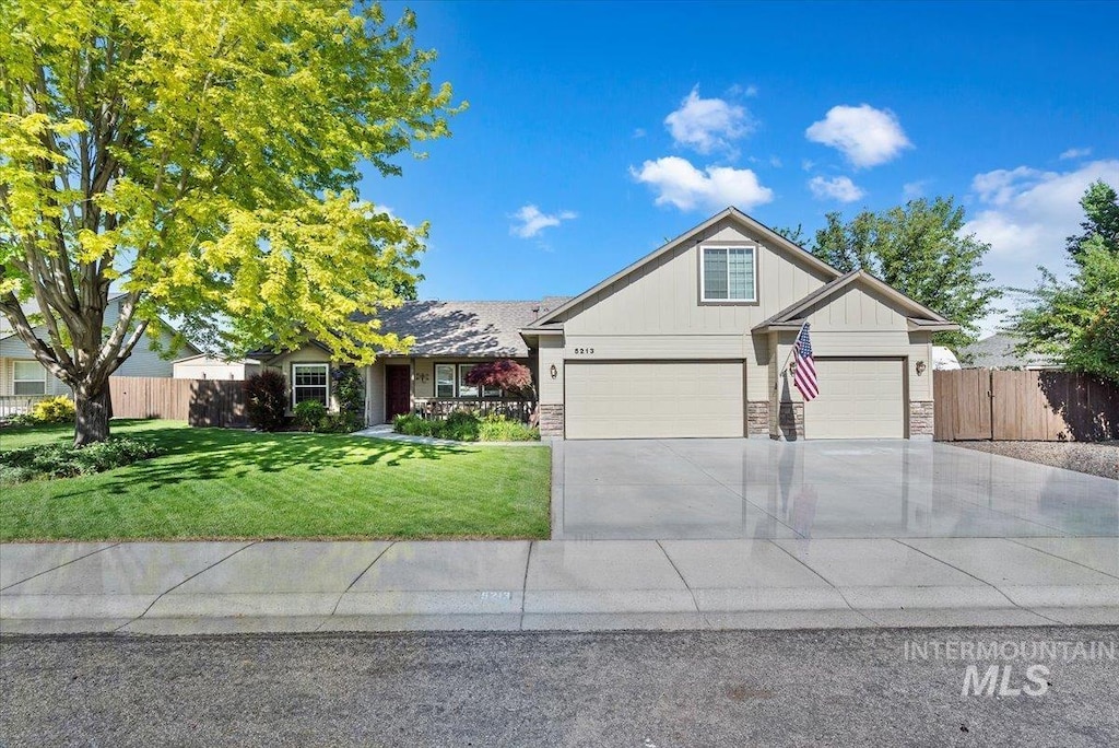 5213 S Walcott Ave, Boise, ID 83709 - view of front facade featuring driveway, board and batten siding, stone siding, and a garage