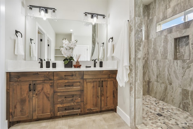 bathroom featuring a tile shower and vanity