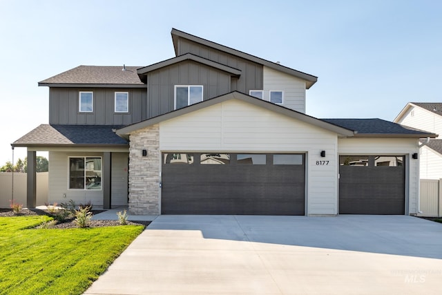 view of front of home featuring fence, roof with shingles, concrete driveway, a garage, and board and batten siding