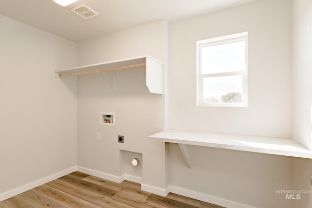 laundry area featuring electric dryer hookup, visible vents, wood finished floors, hookup for a washing machine, and laundry area