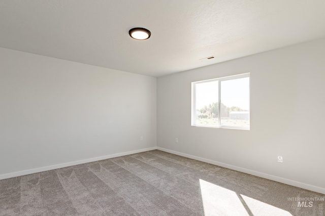 unfurnished room with visible vents, carpet flooring, and baseboards