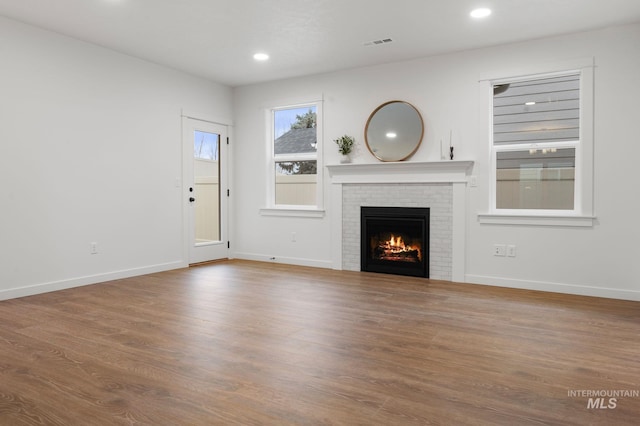 unfurnished living room featuring a fireplace and wood-type flooring