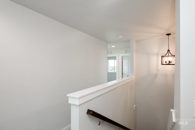 hallway with visible vents and an upstairs landing