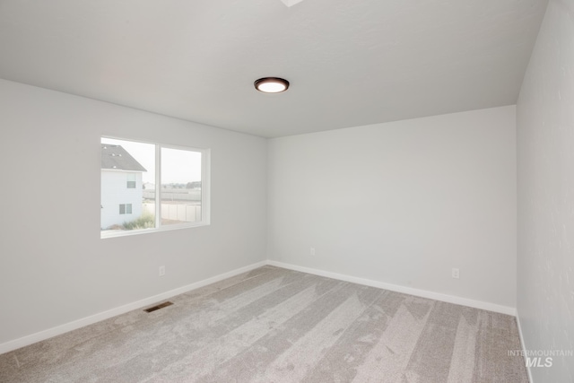 empty room with light carpet, baseboards, and visible vents