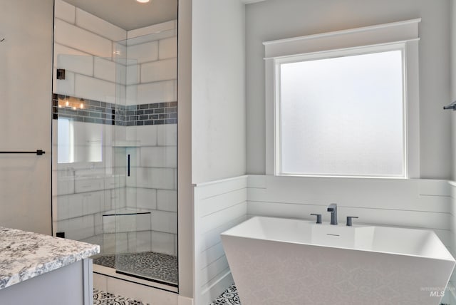 bathroom with a sink, a soaking tub, and a shower stall