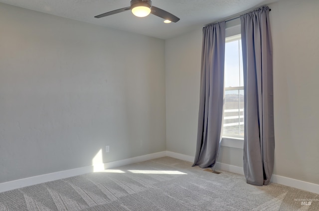 spare room featuring light colored carpet, baseboards, and a healthy amount of sunlight